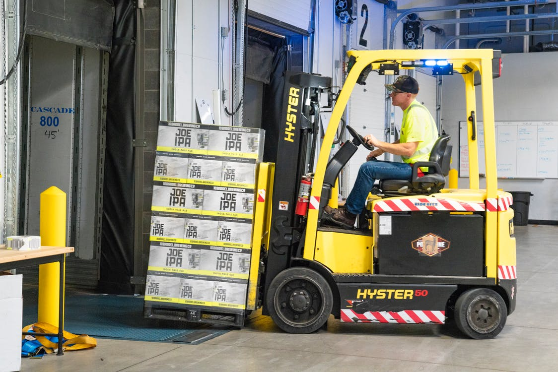 A yellow forklift lifting loads