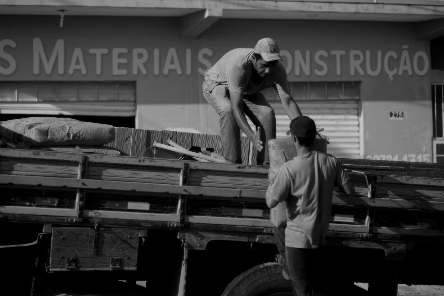 Workers loading heavy weights on a truck