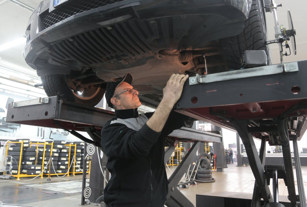 Man inspecting a vehicle on a lift table