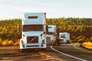 Three trucks on the side of a road.