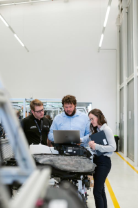 Factory supervisors discussing something while using a laptop