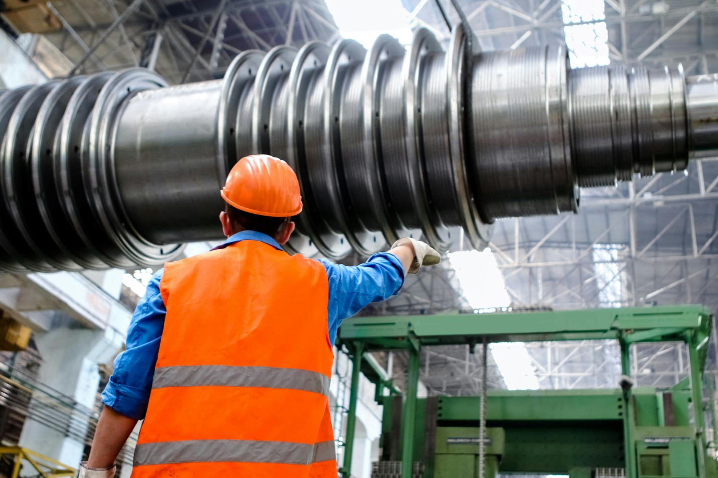 An industrial manager directing a machine operator