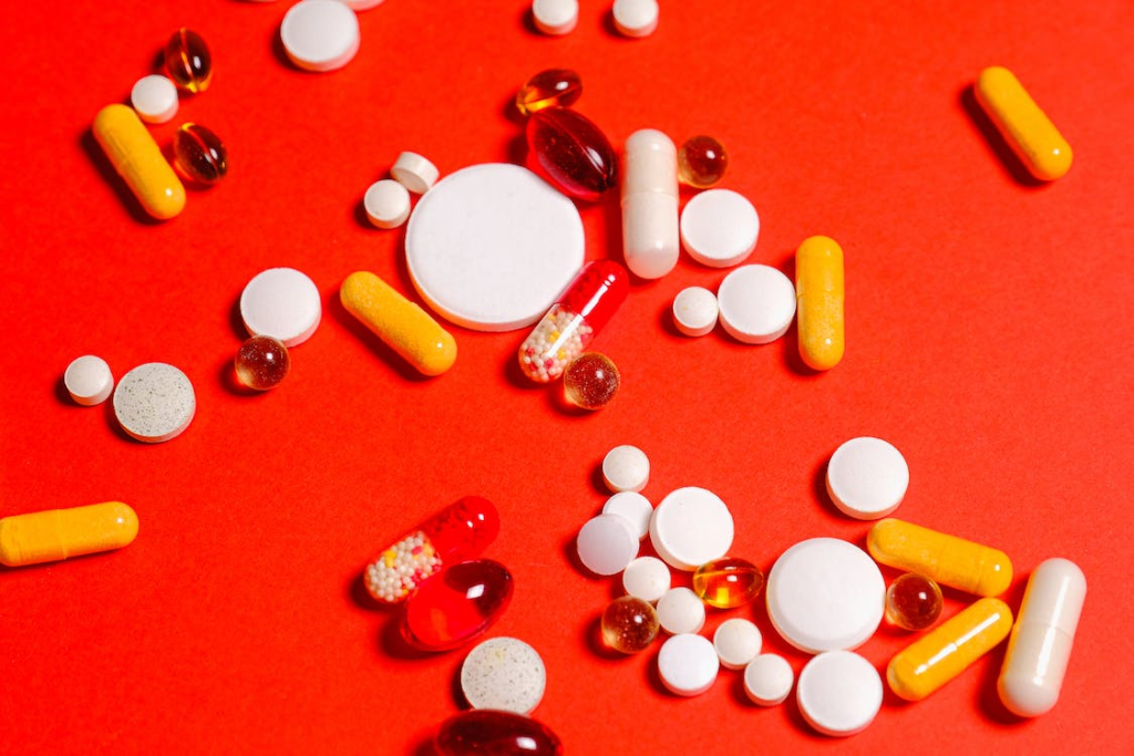 different types of medicines on a red surface